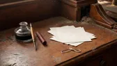 Inkwell kaca antik berisi tinta dengan pena celup dan lembaran kertas kosong di meja tulis kayu, cahaya lampu hangat